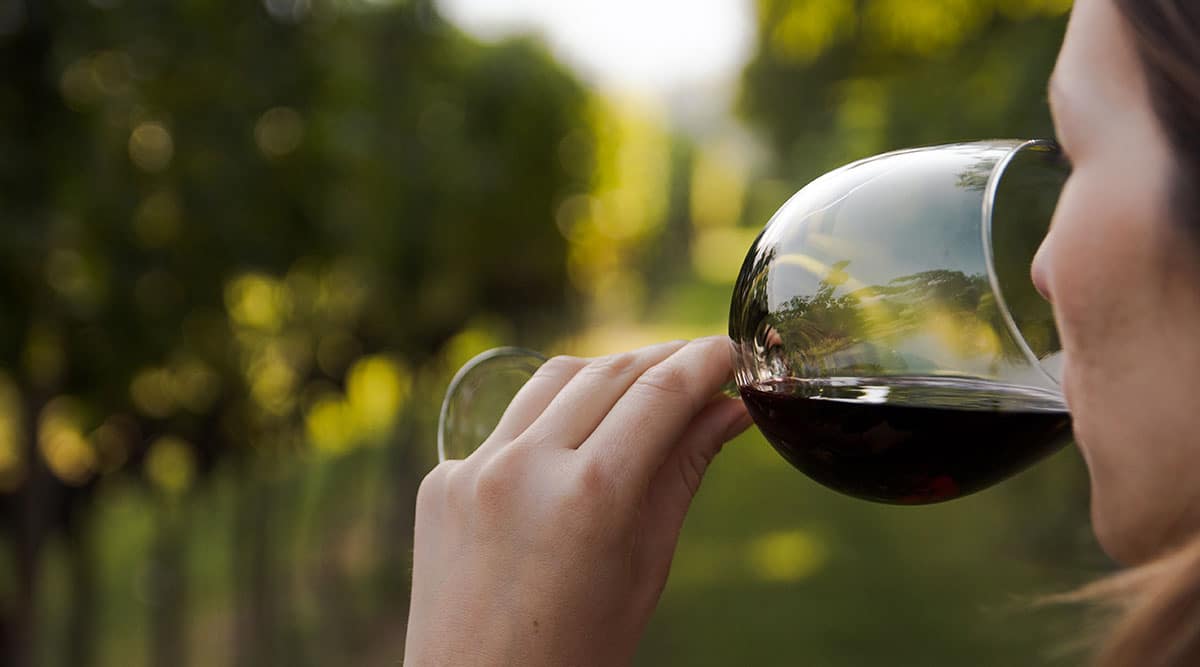Woman drinking a glass of red wine outdoors