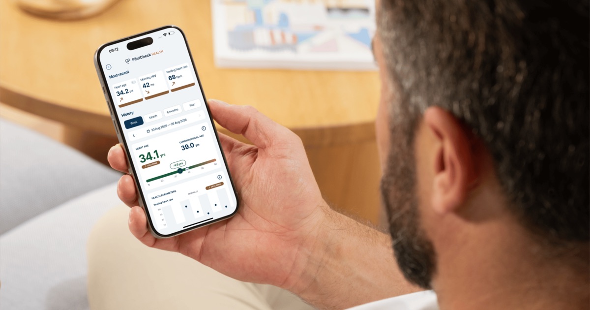 Someone looking at the FibriCheck Health screen on their phone, showing a heart age of 34.1 years against a chronological age of 39.0 years, alongside morning HRV of 42 ms, a resting heart rate of 68 bpm and a week of history.