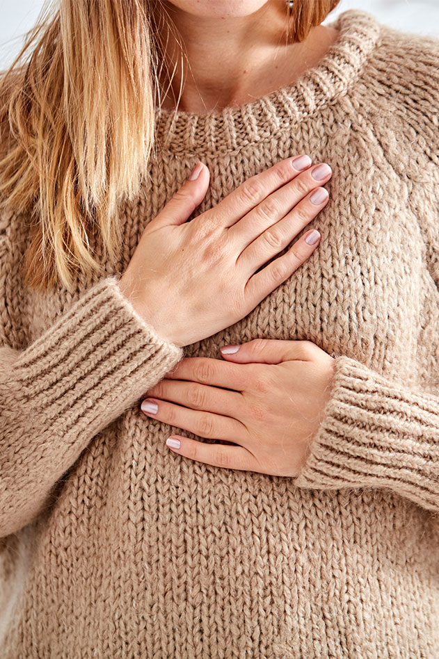 woman holding hands over her chest